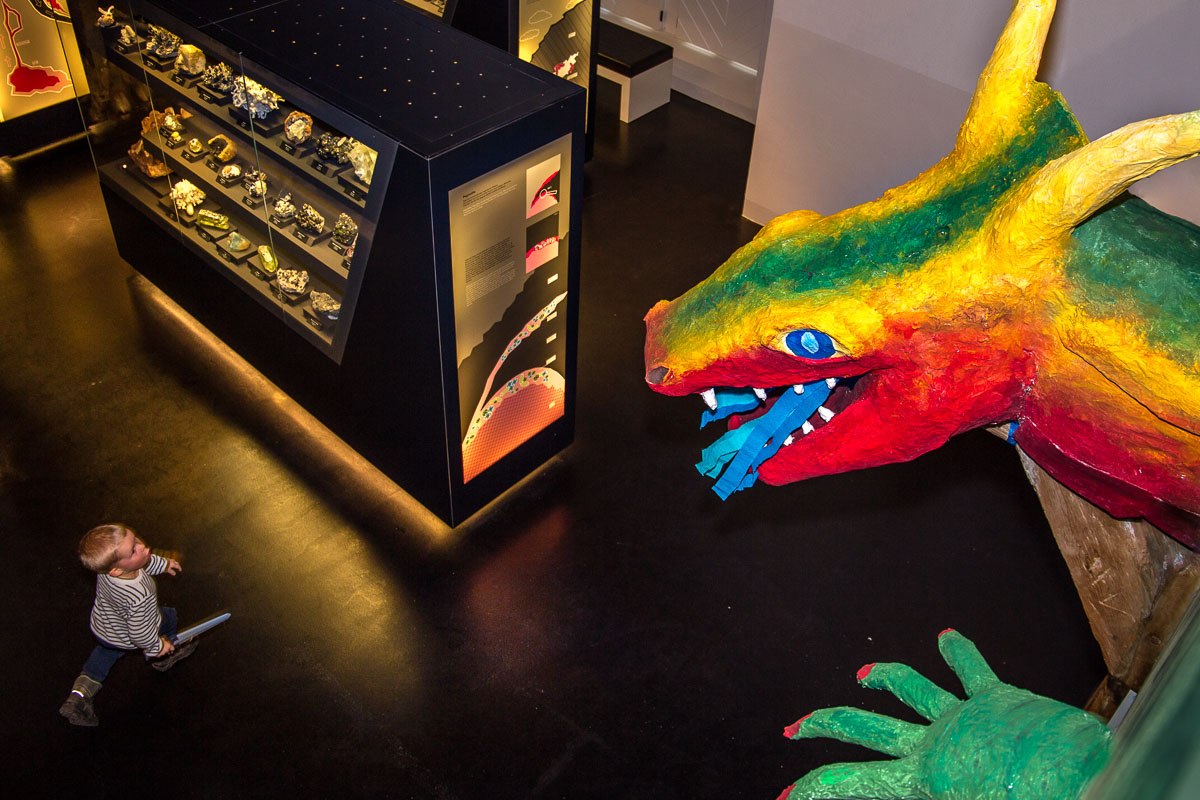Child in exhibition marvels at large colourful fantasy dragon