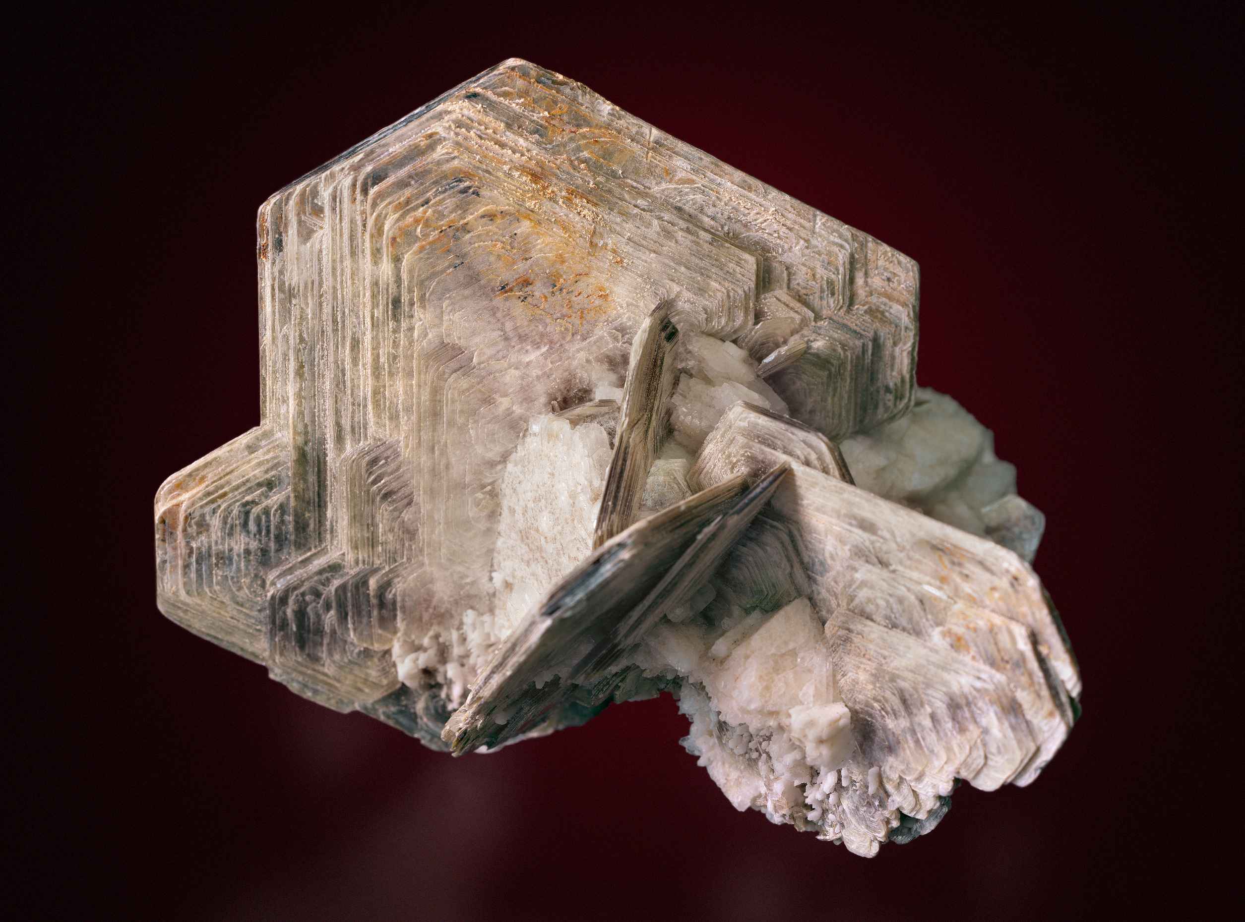 Ein helles Mineral, welches geometrische, geschichtete Formen ausgebildet hat.