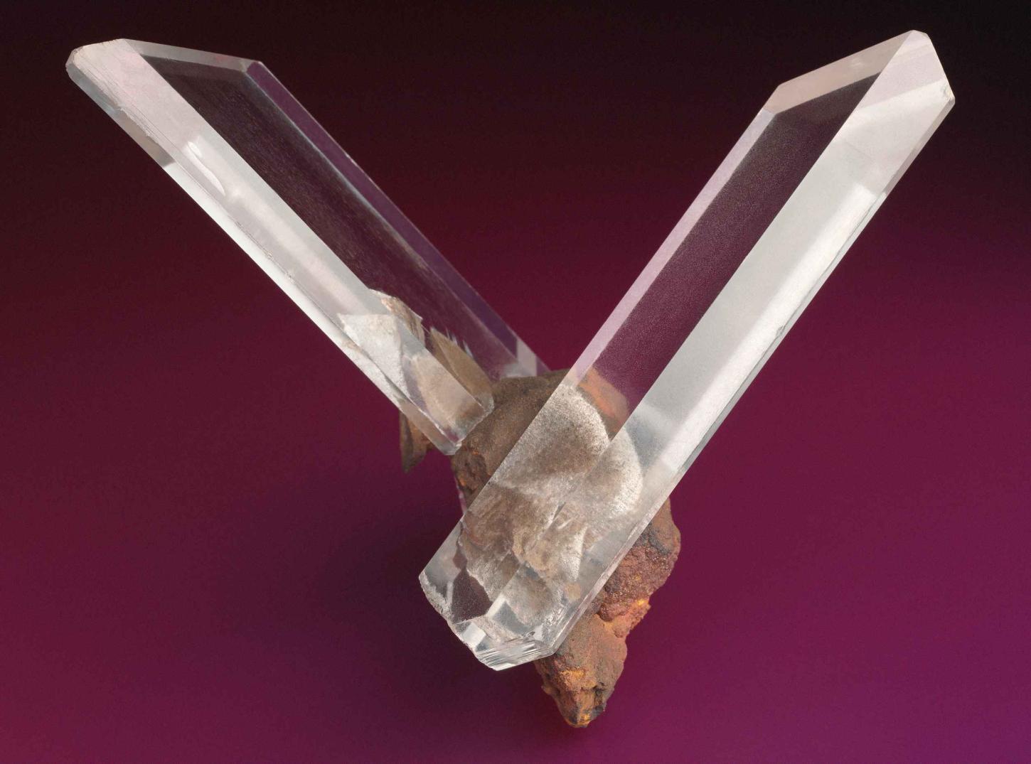 zwei glasklare Gipskristalle sind V-förmig zueinander verwachsen 